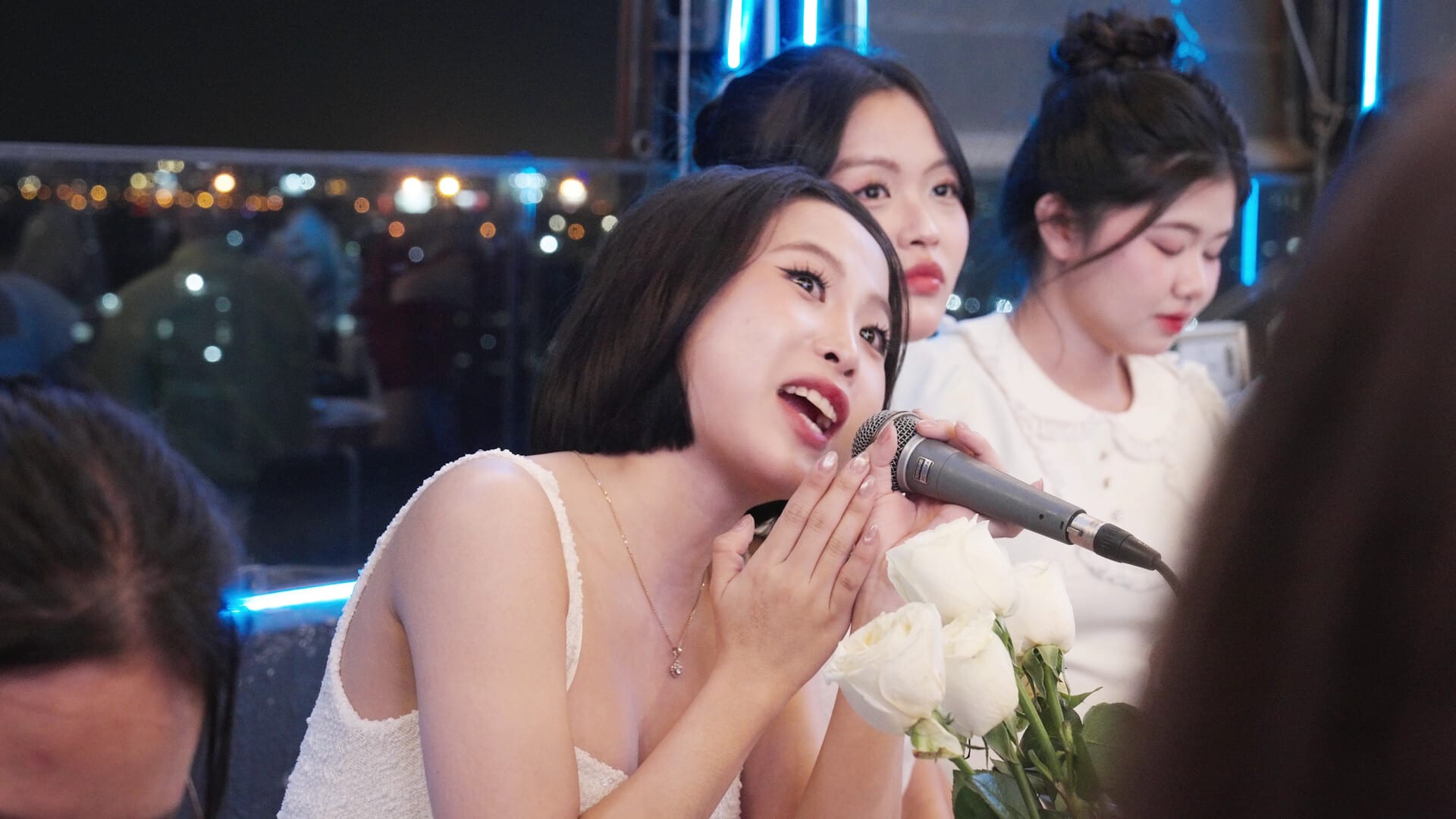 Khách nữ cầm micro hát trong tiệc tất niên ngoài trời