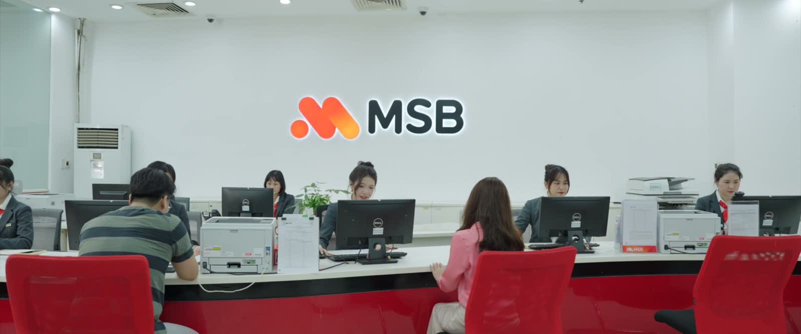Quầy giao dịch MSB với nhân viên và khách hàng trong cùng khung hình.