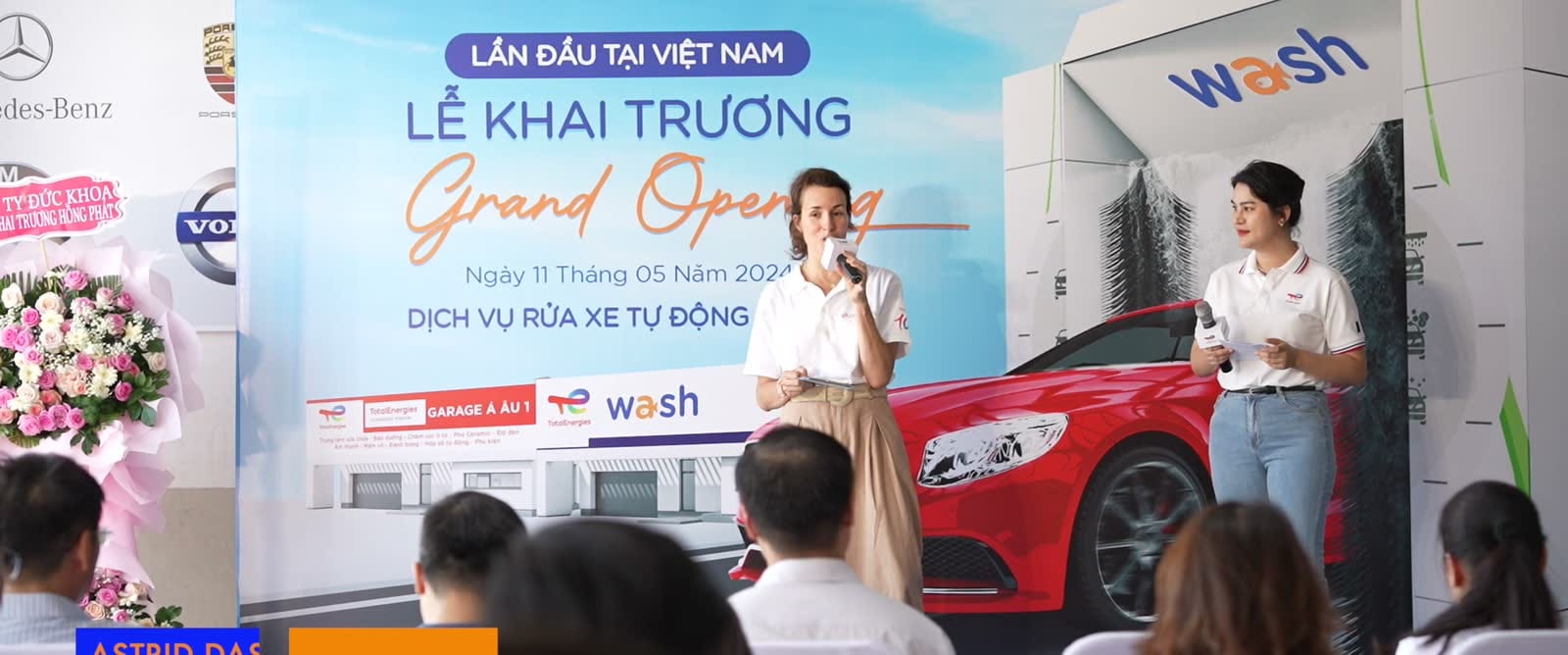 Hai người dẫn giới thiệu trên sân khấu lễ khai trương dịch vụ rửa xe tự động Wash