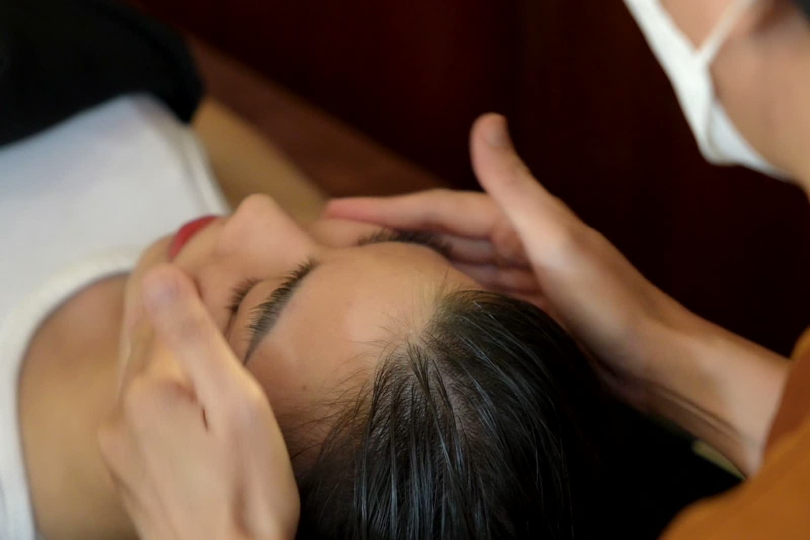 Kỹ thuật viên thực hiện thao tác chăm sóc trên đầu khách hàng tại Thở Spa.