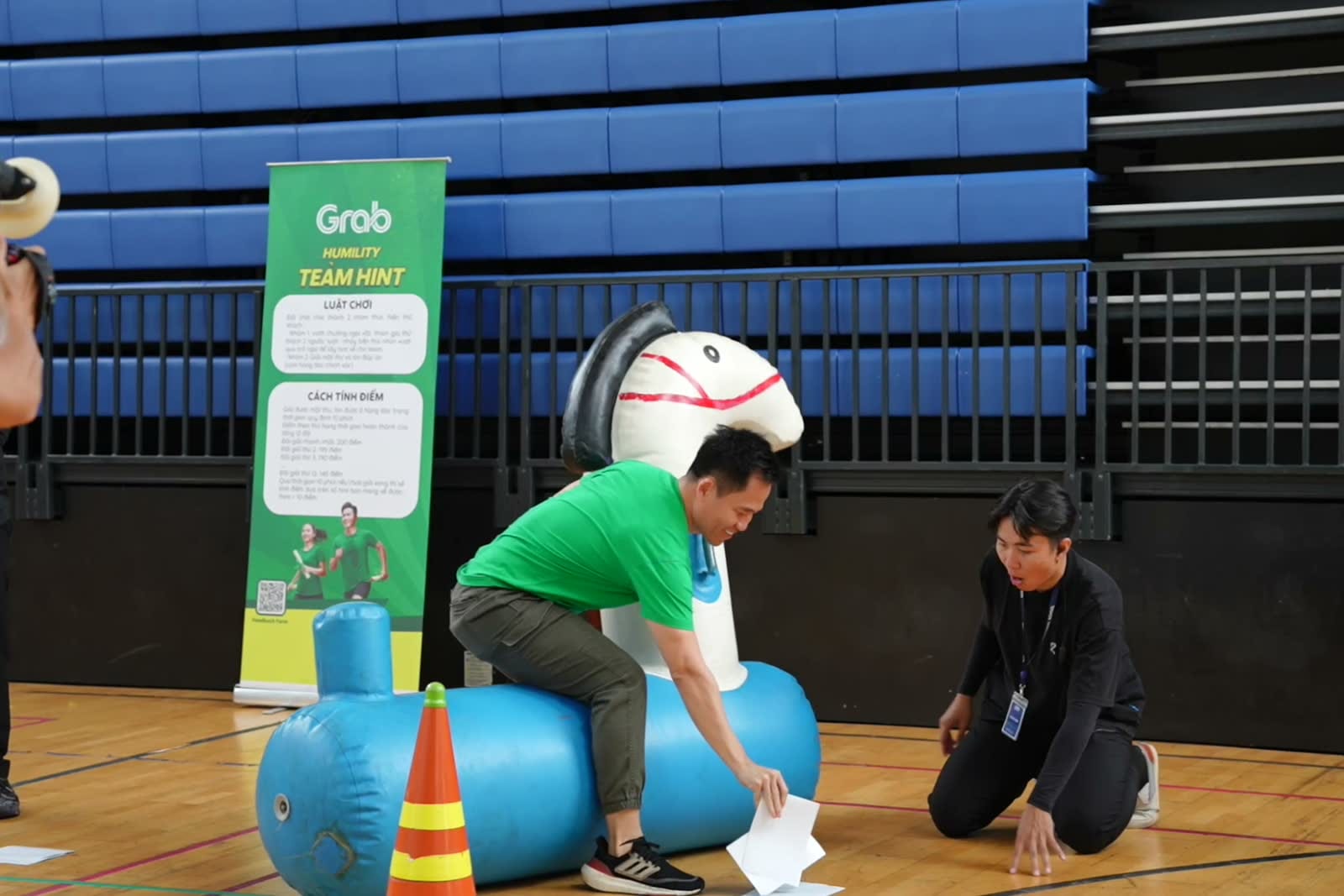 Đội Grab phối hợp với dụng cụ vòng phao trong một trò chơi vận động.