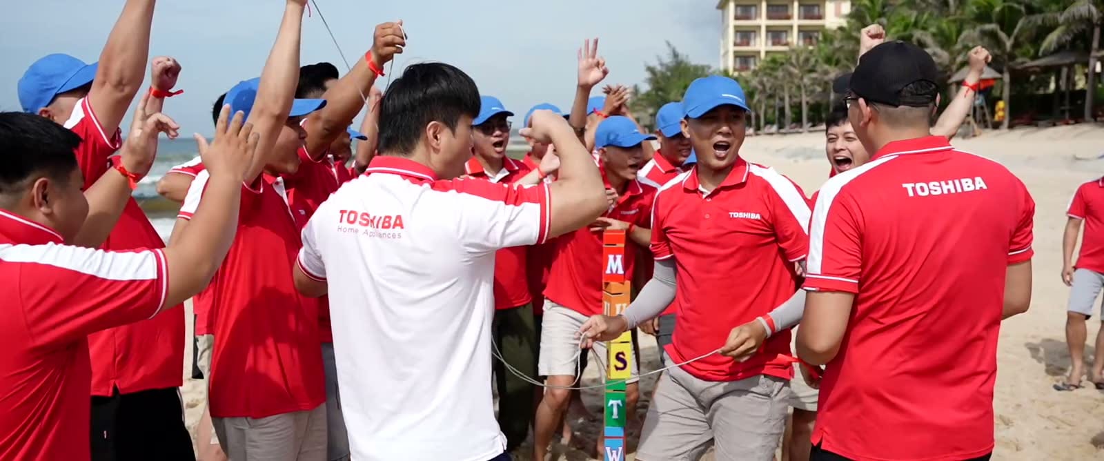 Nhóm thành viên Toshiba cùng reo hò trên bãi biển.