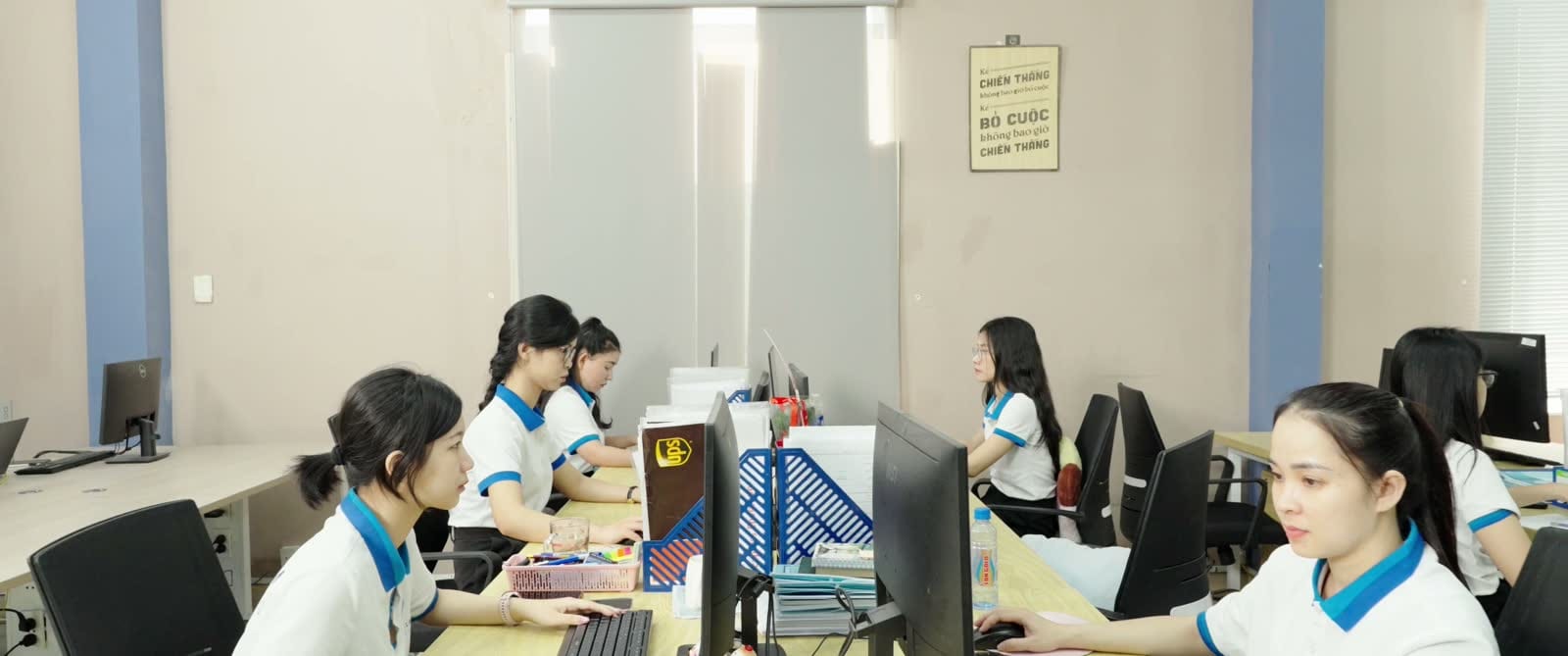Nhân viên văn phòng làm việc bên dãy máy tính trong phòng làm việc chung