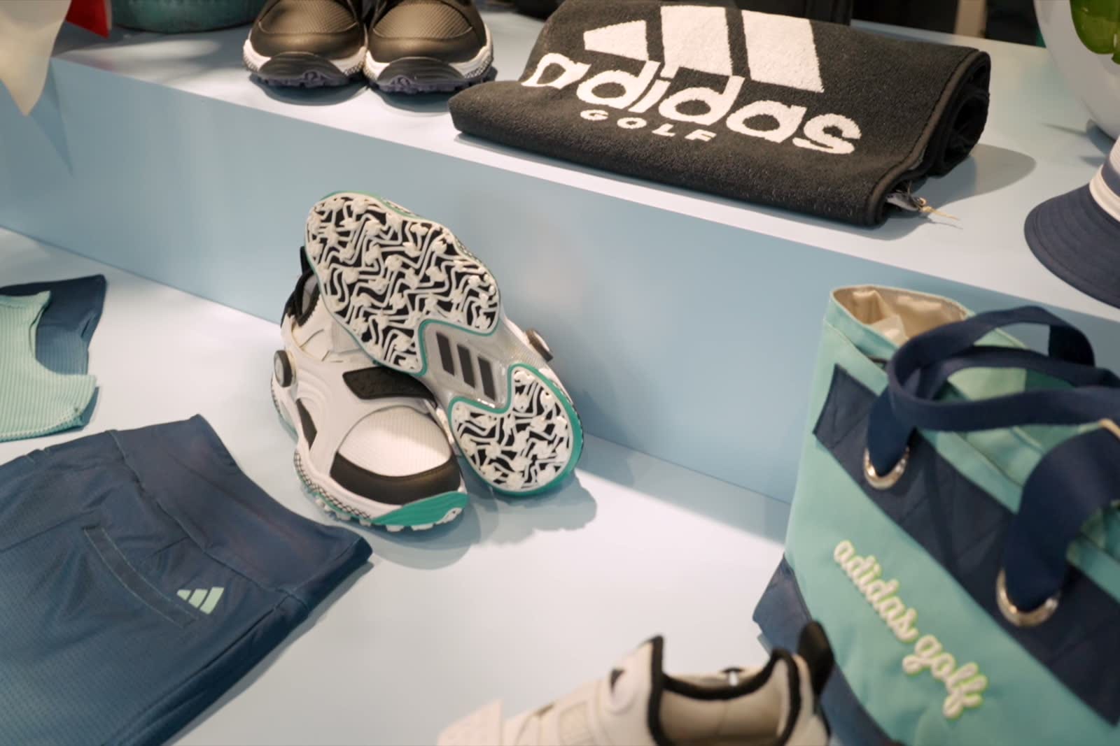 Khu trưng bày giày, túi và phụ kiện ADIDAS Golf trong cửa hàng.